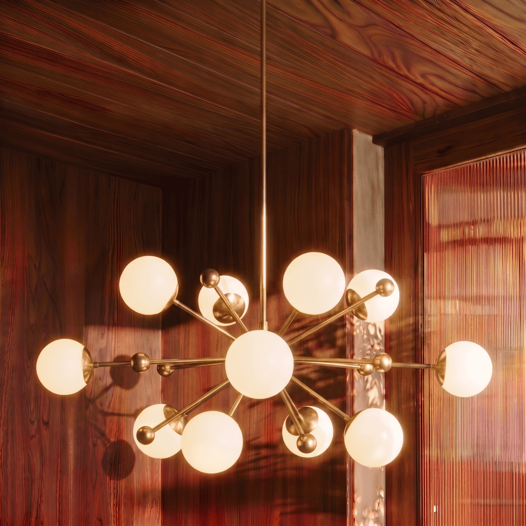 Clérachic chandelier in brushed brass glowing in a rich walnut-paneled room with fluted glass.
