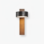Product shot of this Clérachic wall light on white, its black travertine drum sitting above a walnut wood bar.