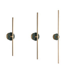 Three Clérachic wall sconce units lined up on white, each fitted with a green stone disc at a different height.