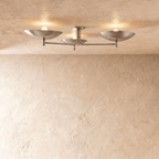 Clérachic ceiling light with three boat-shaped shades glowing softly against a textured plaster ceiling.