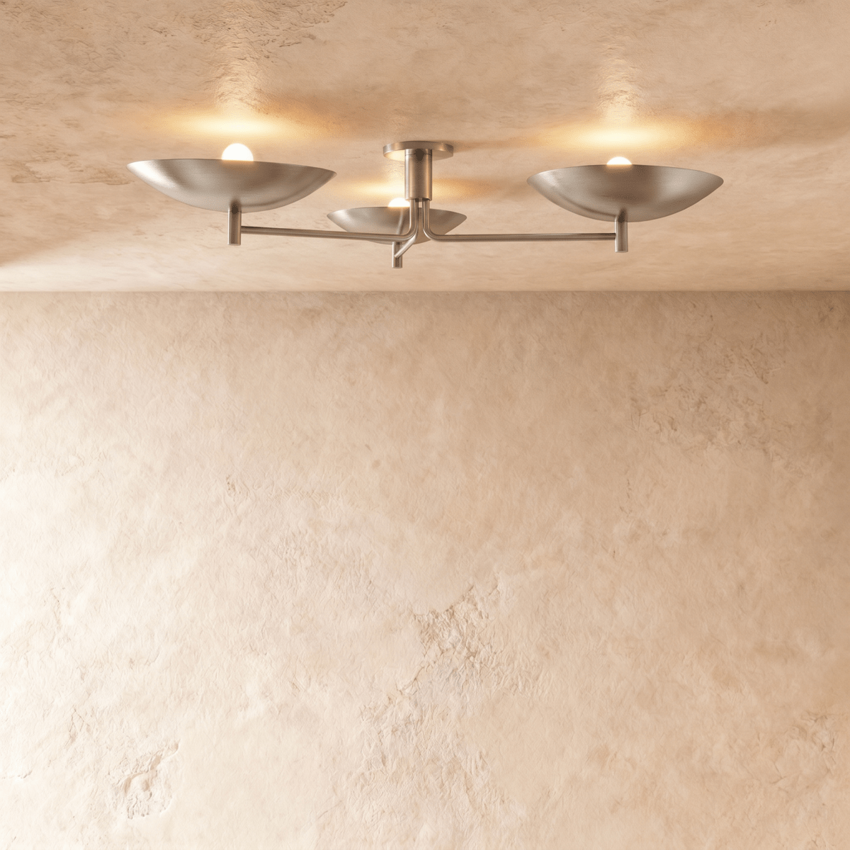 Clérachic ceiling light with three boat-shaped shades glowing softly against a textured plaster ceiling.