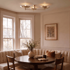 Clérachic ceiling light in brass lighting a curved banquette table in a bay-window breakfast nook.