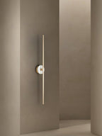 Clérachic wall sconce mounted in a narrow taupe hallway corner, its stone disc sitting just beside an open doorway.