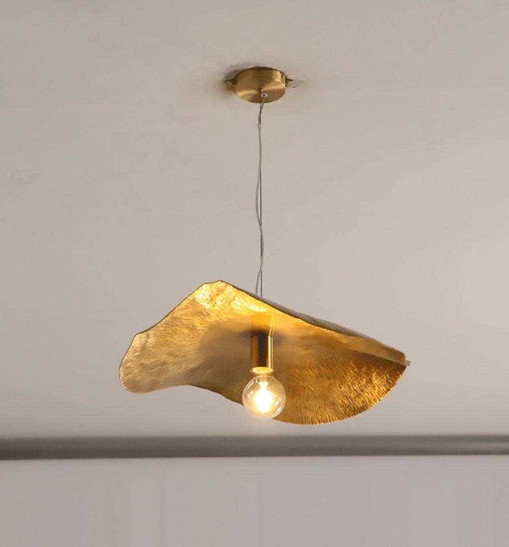 This Clérachic pendant hangs lit from a round brass ceiling mount in a bare studio setting.