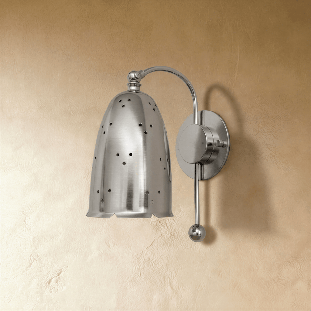 Clérachic wall lamp in chrome shown from another angle, pinholes of light dotting the bell shade.