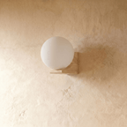 Clérachic globe wall light in the larger size against a plain wall