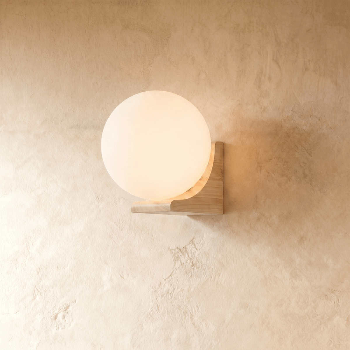 Close view of the Clérachic globe wall light where the glass meets the wood