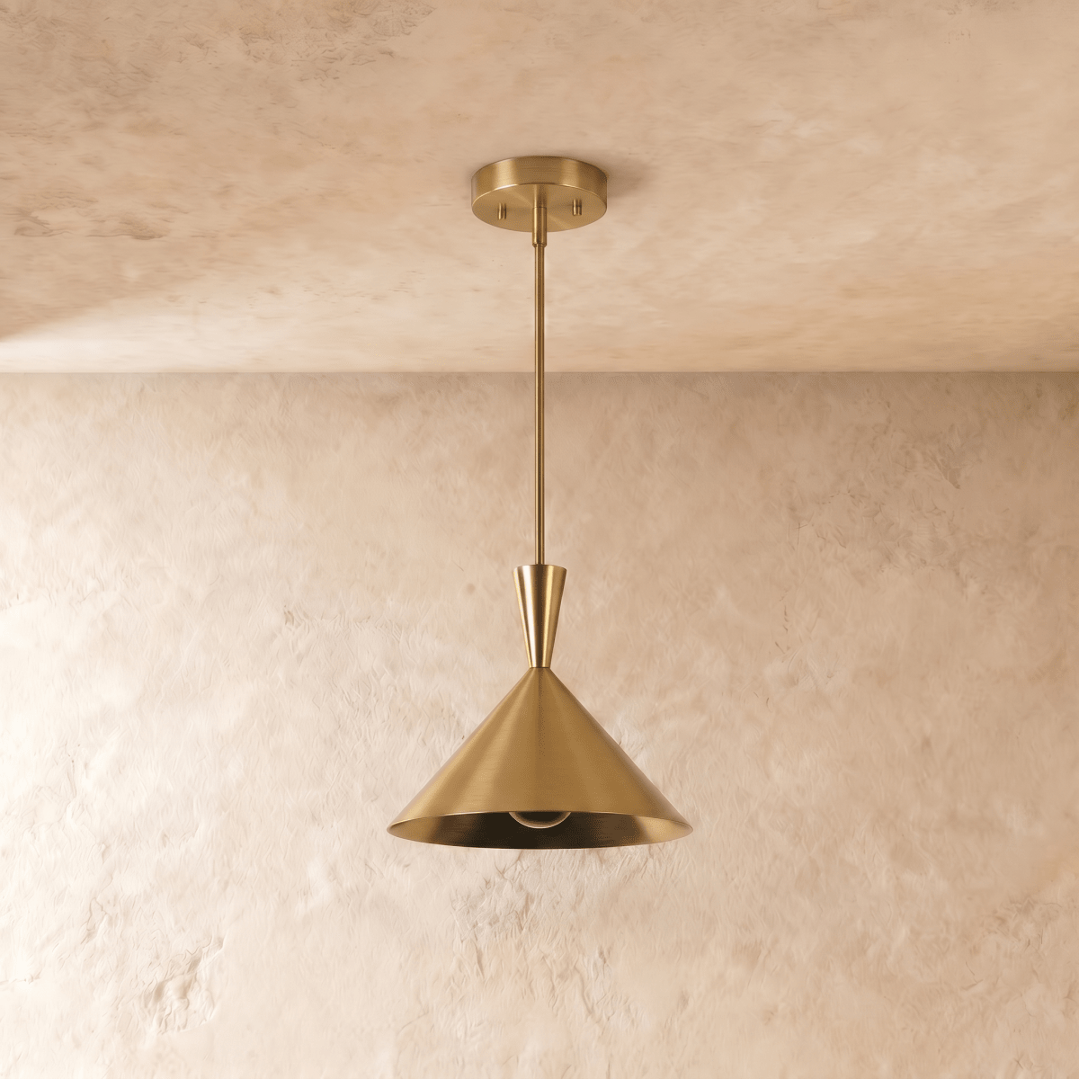 Clérachic cone-shade pendant light in a brass finish, photographed straight on and unlit, showing the straight-sided cone and the bulb sitting just inside its open mouth.