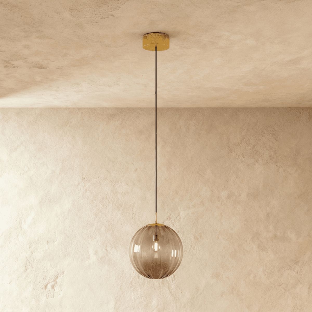 Clérachic smoke-tinted ribbed globe pendant hanging against a limewash wall