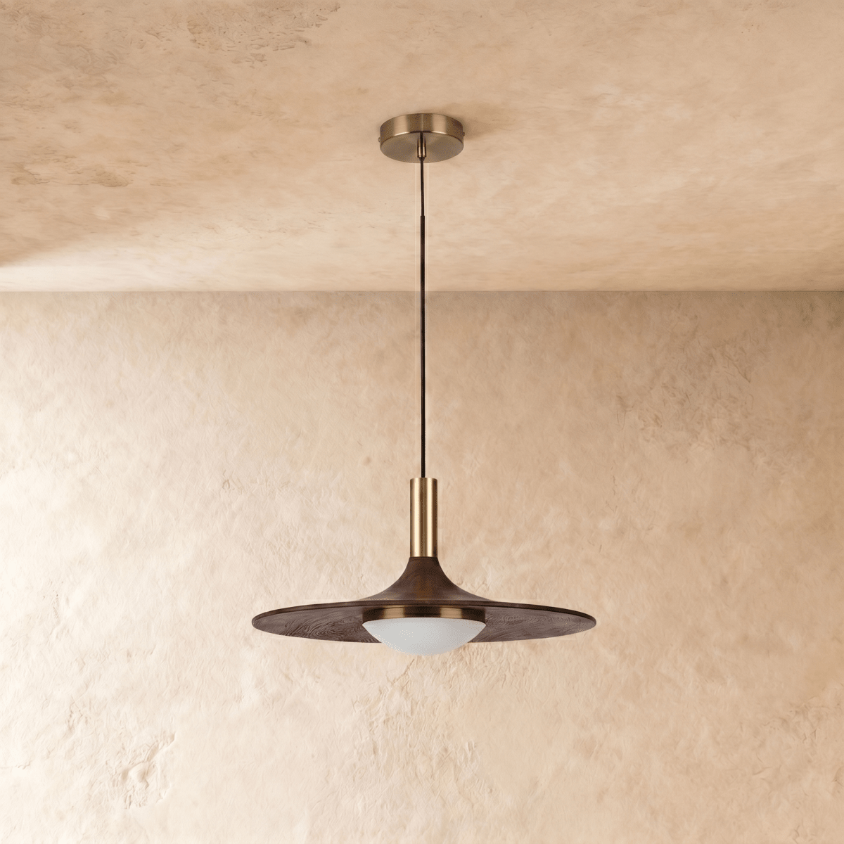 Clérachic bronze saucer pendant hanging unlit against a limewash wall