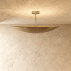 Clérachic ceiling light in a warm satin brass finish, light spilling through its pierced dot pattern.