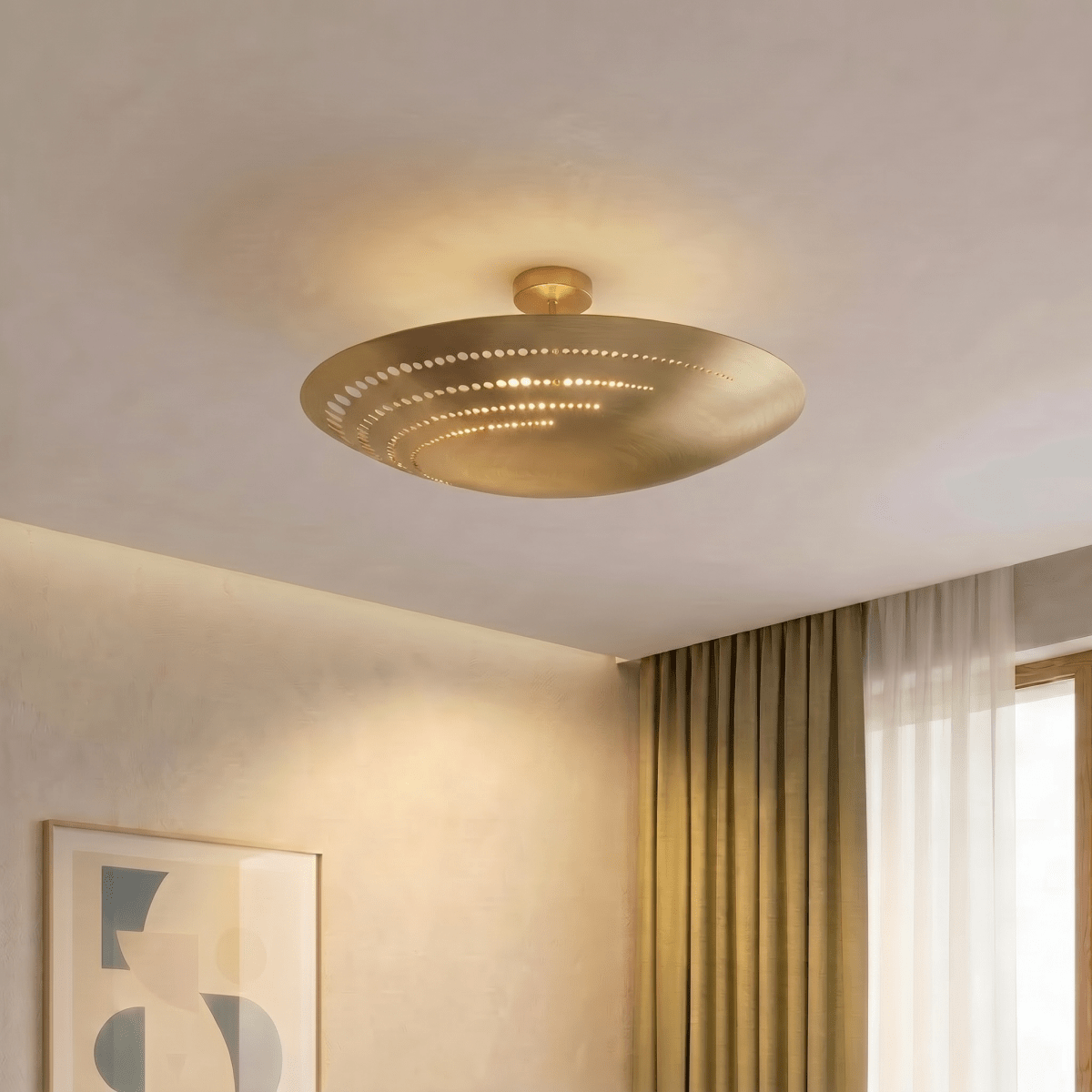 Clérachic ceiling light in brass glowing in a golden-lit living room corner beside floor-length curtains.
