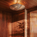 Clérachic ceiling light in chrome glowing in a wood-paneled corner beside a woven strand curtain.