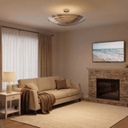 Clérachic ceiling light in chrome glowing above a living room with a stone fireplace and beach art.