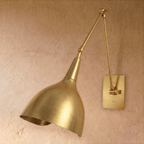 Clérachic wall lamp in polished brass, viewed from a slightly different angle with its cone shade lowered.