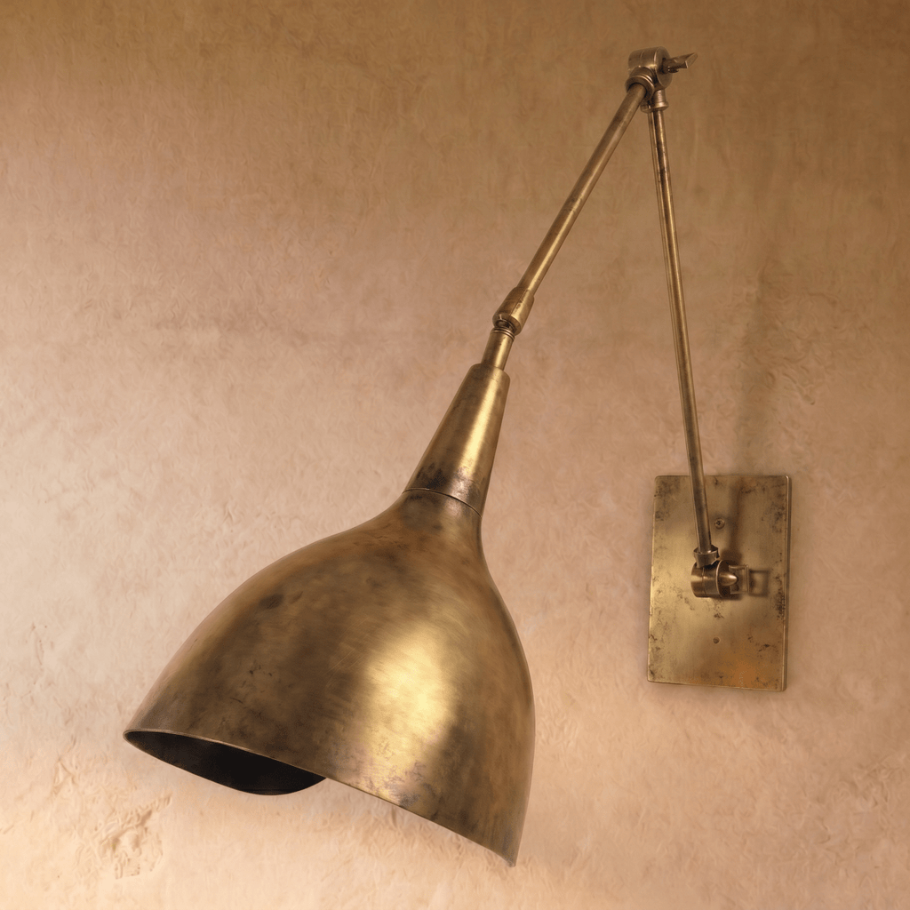This vintage brass Clérachic wall lamp is shown from a slightly different angle, its cone shade tilted down.