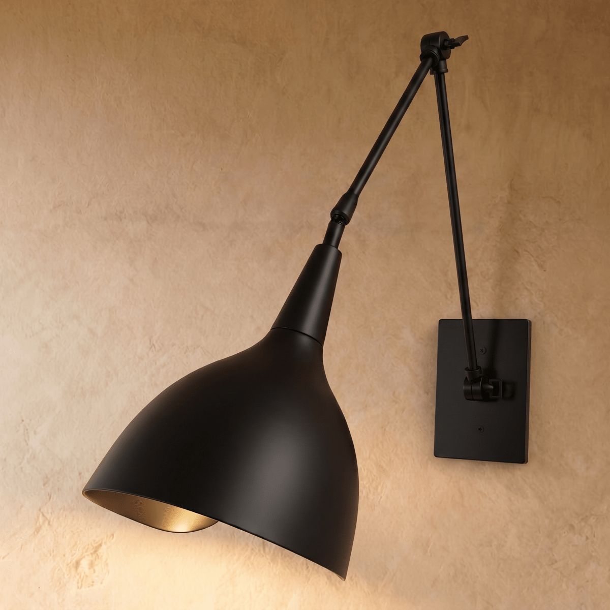 A matte black Clérachic wall lamp with a cone shade on an articulated arm, mounted against a plaster wall.