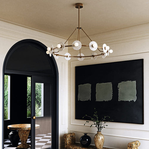 Clérachic 12-Light Alabaster Ring Chandelier lit in a pale entrance hall, beside a black arched doorway and a large dark canvas.