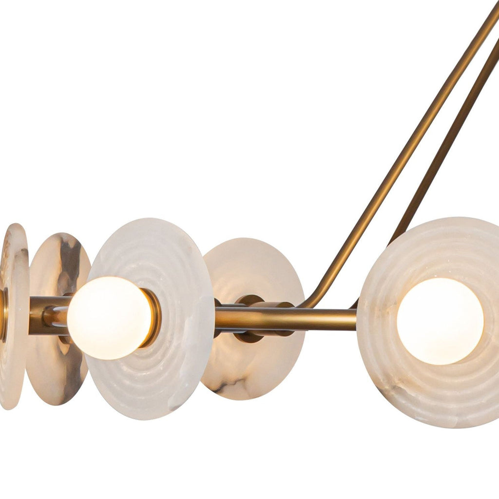 Close view of the Clérachic ring chandelier's copper hoop, lit opal globes seated in ribbed alabaster discs.
