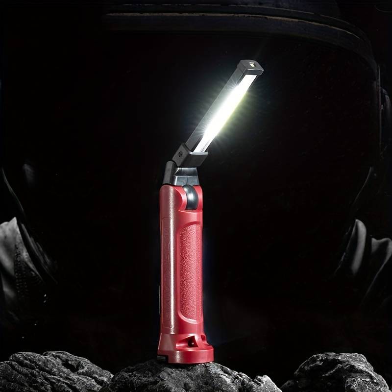 The Clérachic work light standing on rubble in a dark workshop, panel angled upward.