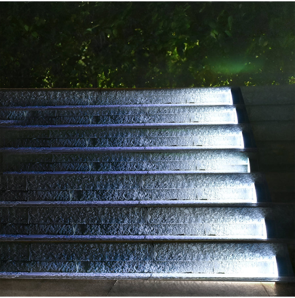 Clérachic step lights lit in cool white along wet stone steps at night.