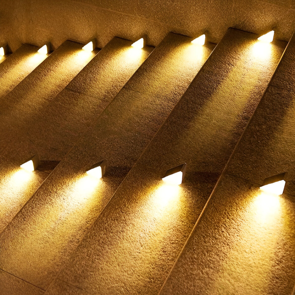 Clérachic step lights seen close on textured concrete stairs, each throwing a warm wedge.