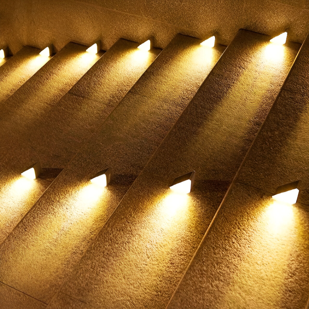 Clérachic step lights seen close on textured concrete stairs, each throwing a warm wedge.