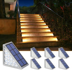 Seven Clérachic step lights shown beside a lit stone staircase in a planted garden.