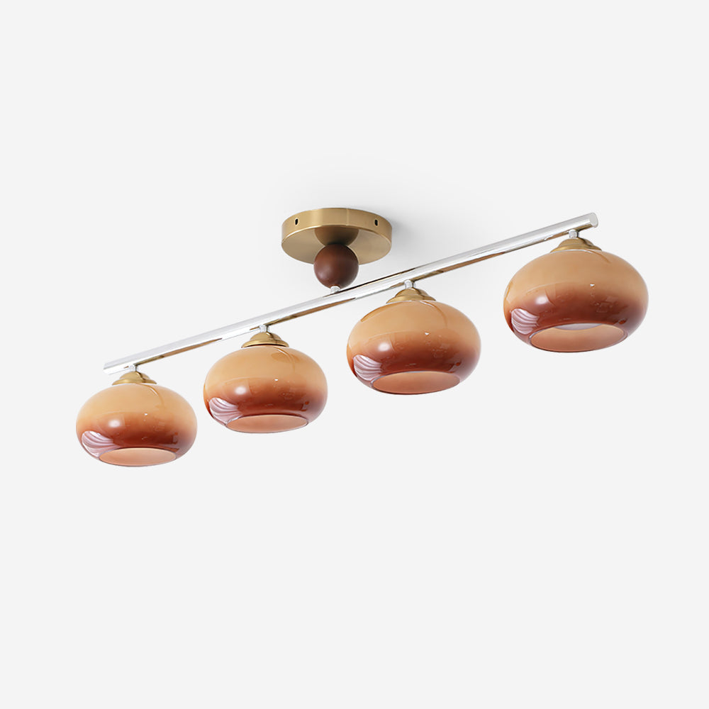 Clérachic 4-Dome Glass Bar Ceiling Light photographed against plain grey, the off-centre brass canopy carrying the whole caramel bar.