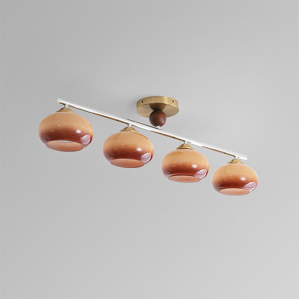 Clérachic 4-Dome Glass Bar Ceiling Light seen at an angle in caramel glass, brass canopy off-centre along the run as the design intends.