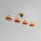 Clérachic 4-Dome Glass Bar Ceiling Light seen at an angle in caramel glass, brass canopy off-centre along the run as the design intends.
