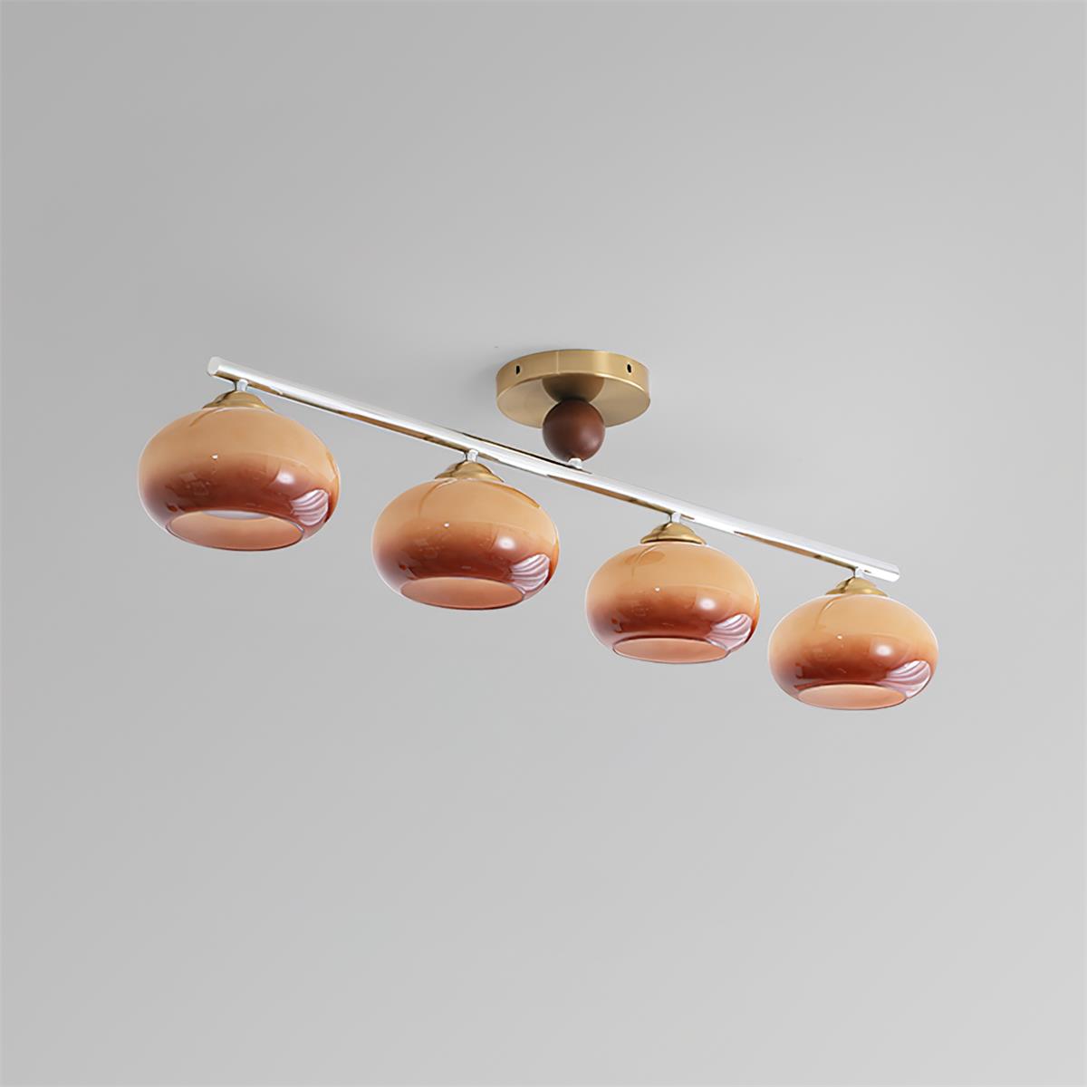 Clérachic 4-Dome Glass Bar Ceiling Light seen at an angle in caramel glass, brass canopy off-centre along the run as the design intends.