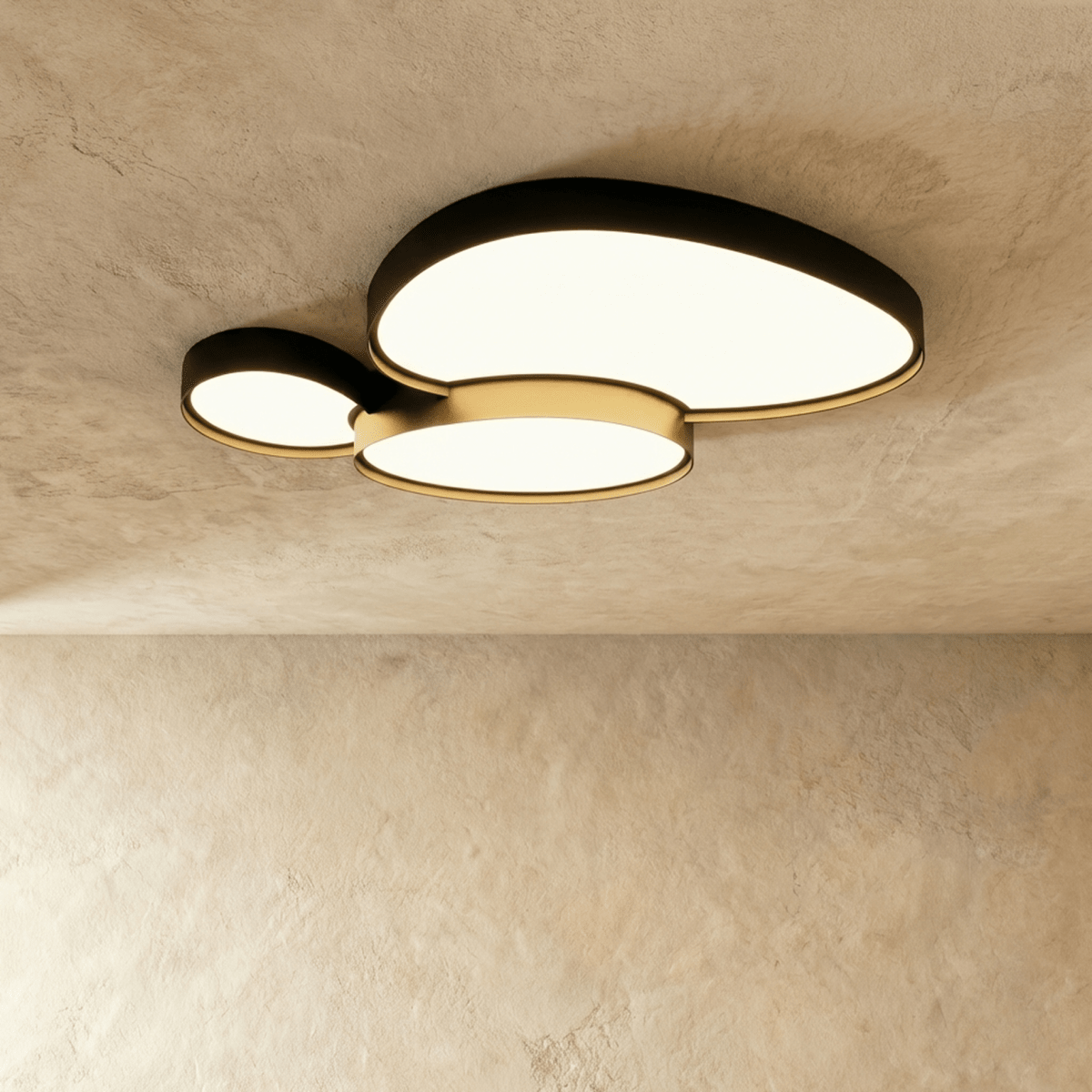 The Clérachic black ceiling light seen from below, two overlapping oval discs casting a soft warm white glow across the room.