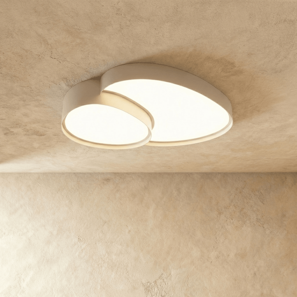 The Clérachic ceiling light in matte white, overlapping acrylic discs glowing warm white against a soft plaster ceiling.