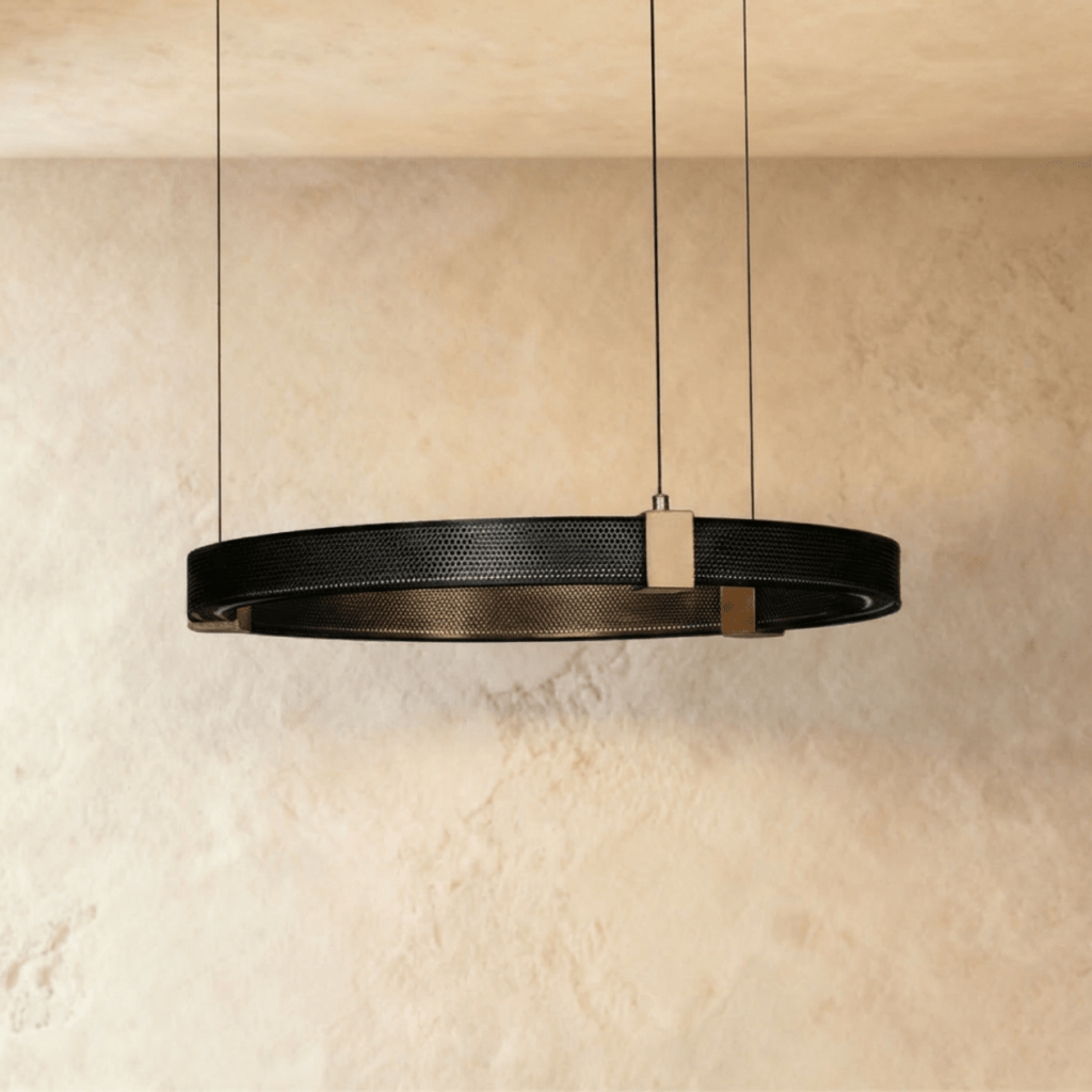Clérachic ring chandelier, a single black perforated-metal ring with brass mounts, hung from a plaster ceiling.