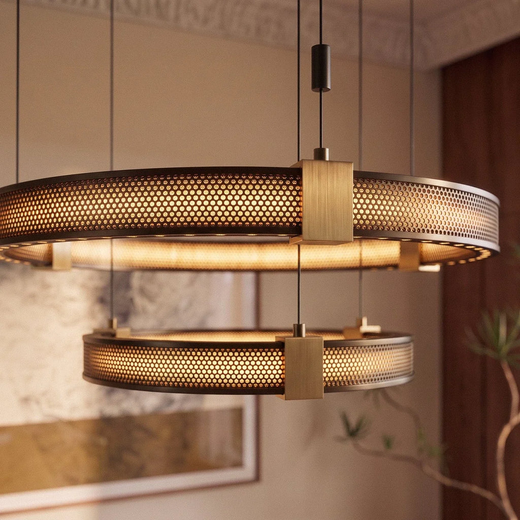 Clérachic ring chandelier detail, warm light through the perforated black metal bands and brass connectors.