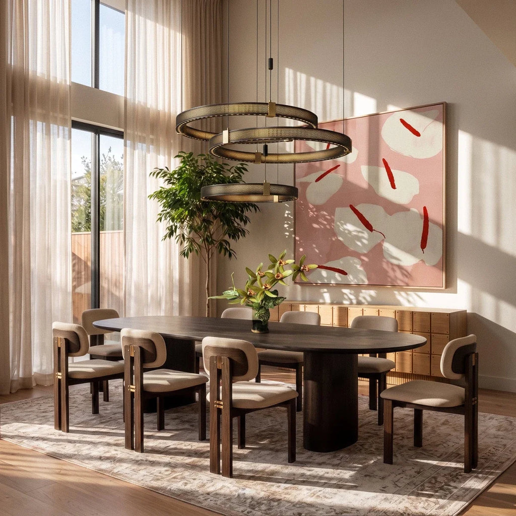 Clérachic three-tier ring chandelier lit warm above a long oval dining table with upholstered dining chairs.