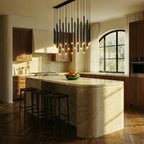 Clérachic dense cluster of black tube pendants above a marble kitchen island, with walnut cabinets and an arched window beyond.