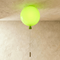 Clérachic balloon-shaped ceiling light in glossy lime green with a matching cone and pull cord, lit against a limewashed ceiling.