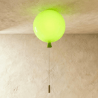 Clérachic balloon-shaped ceiling light in glossy lime green with a matching cone and pull cord, lit against a limewashed ceiling.