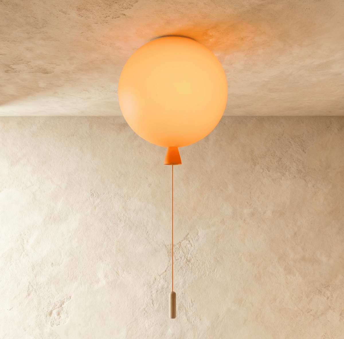 Clérachic balloon-shaped ceiling light glowing soft orange, with an orange cone neck and cord, fixed to a plaster ceiling.