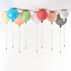 Clérachic balloon ceiling lights in a row on a white ceiling, in blue, peach, green, coral, white, grey and pale yellow with pull cords.
