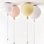 Clérachic balloon ceiling lights in white, peach, pale yellow and white hanging side by side with slim cords and chrome ceiling plates.