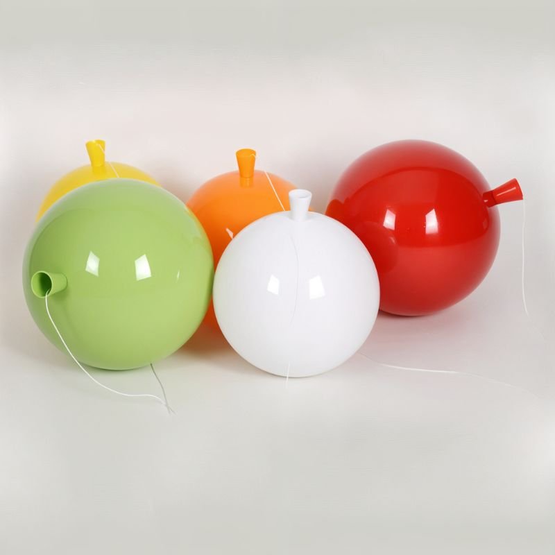 Clérachic glossy balloon lamp globes in green, yellow, orange, white and red laid on their sides, showing the cone necks and cords.