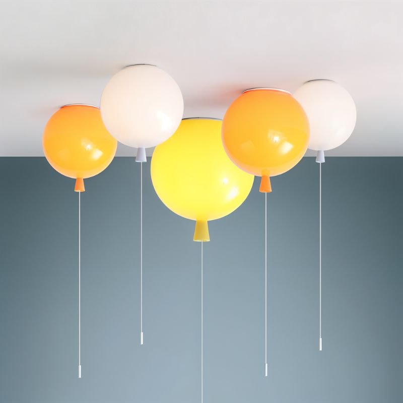 Clérachic balloon ceiling lights in orange, white and yellow clustered on a white ceiling above a slate blue wall, with pull cords.