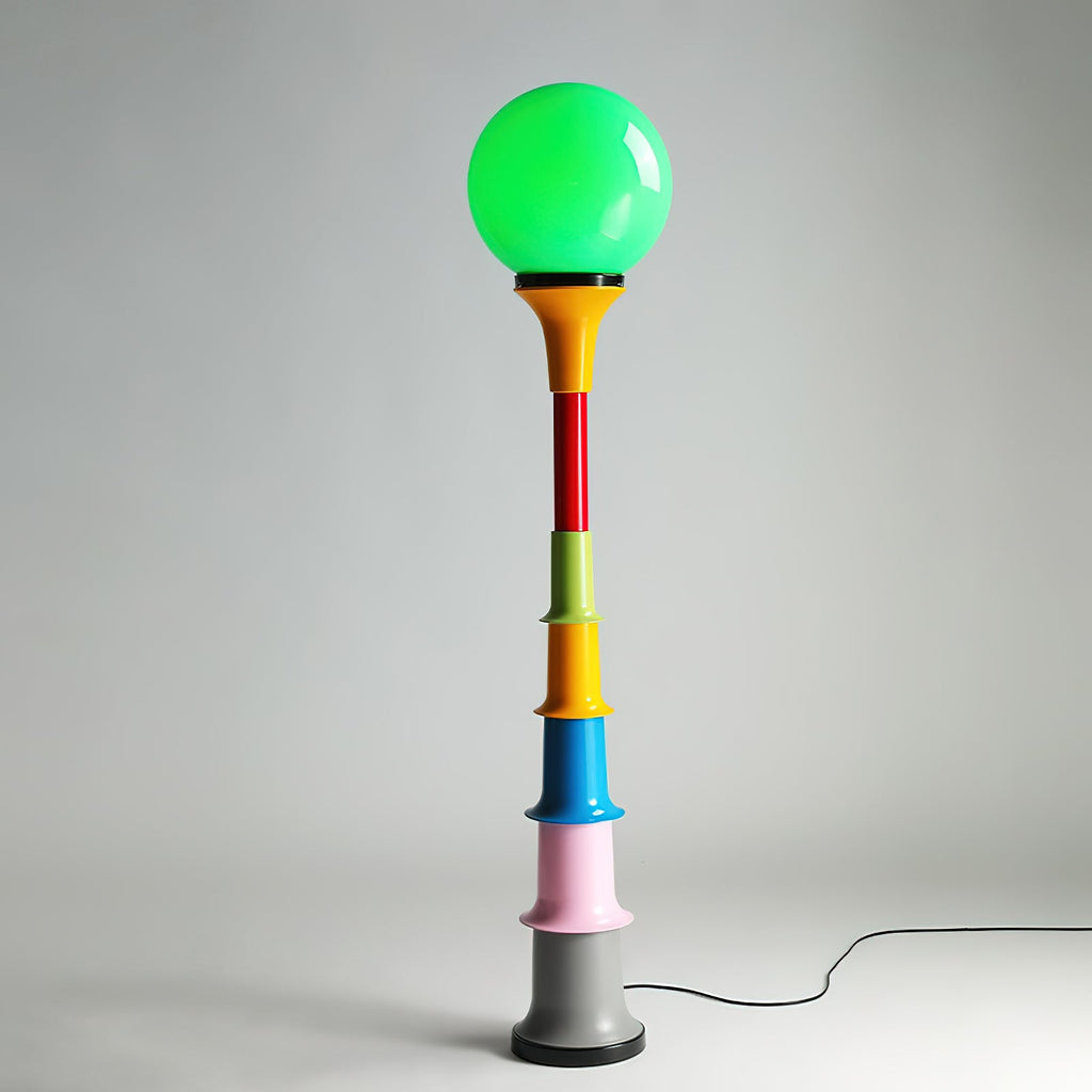 Green-globe Clérachic floor lamp with a yellow funnel, red, green, yellow, blue and pink tiers and a grey foot, on a pale grey backdrop.