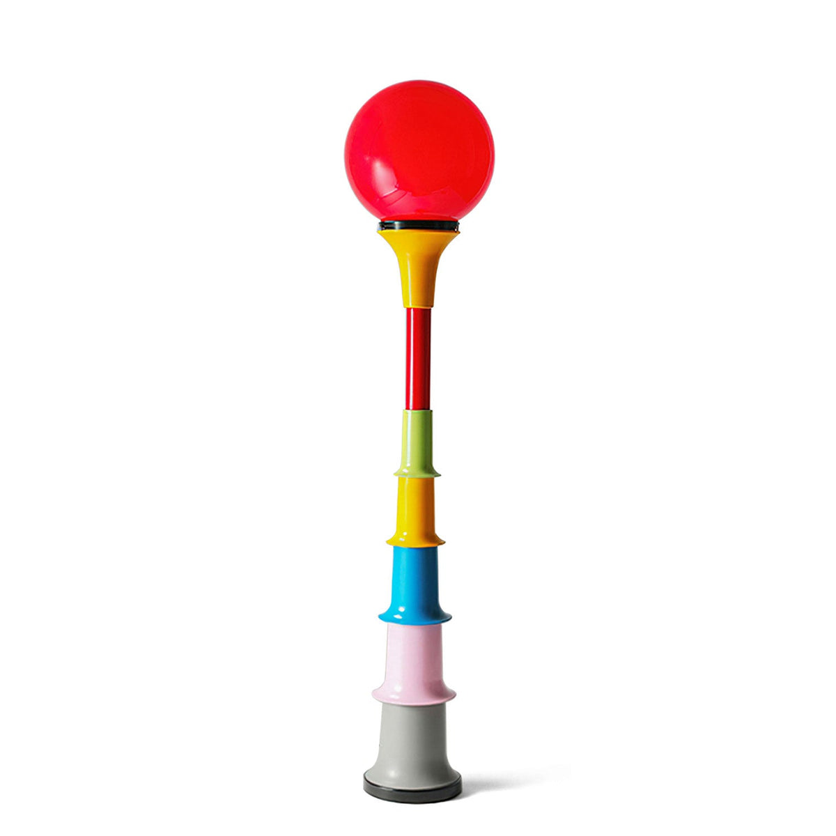 Red-globe Clérachic floor lamp with a multicolour stacked stem and grey foot, on a white backdrop.