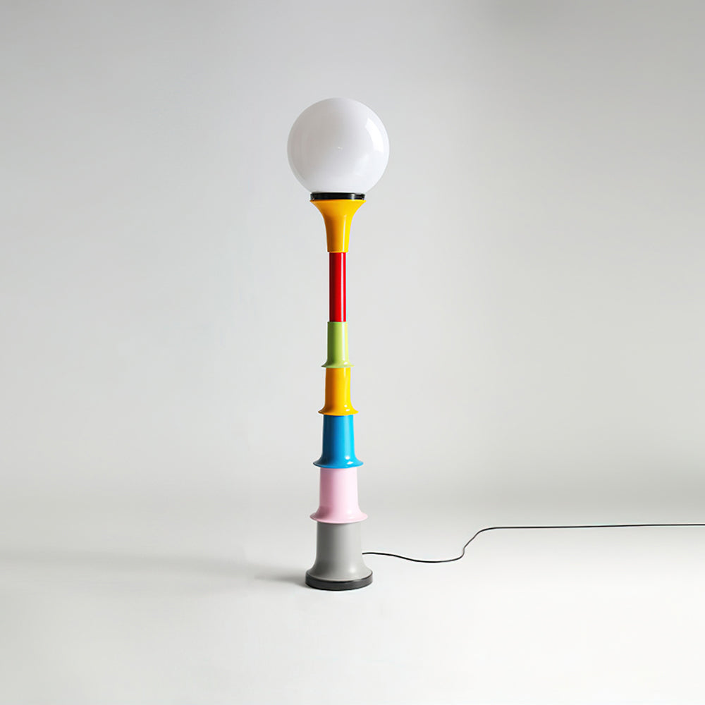 White-globe Clérachic floor lamp with a multicolour stacked stem and grey foot, on a light grey backdrop.
