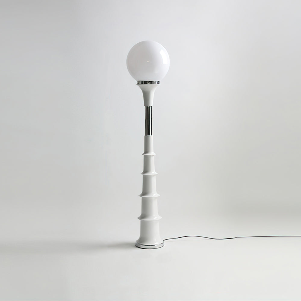 Clérachic floor lamp with a white globe and a pale ribbed stem with a chrome band, on a grey studio backdrop.