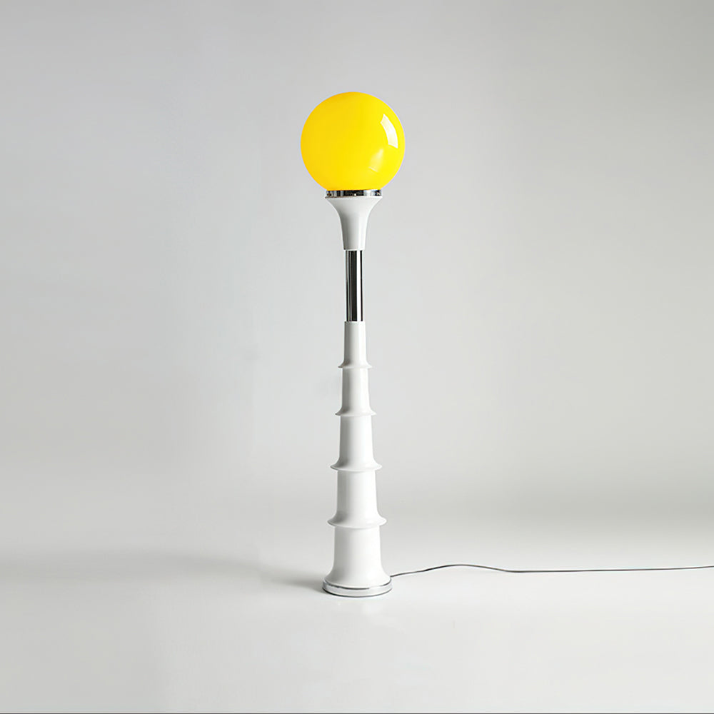 Yellow-globe Clérachic floor lamp with a white ribbed stem and a chrome band, on a plain grey backdrop.